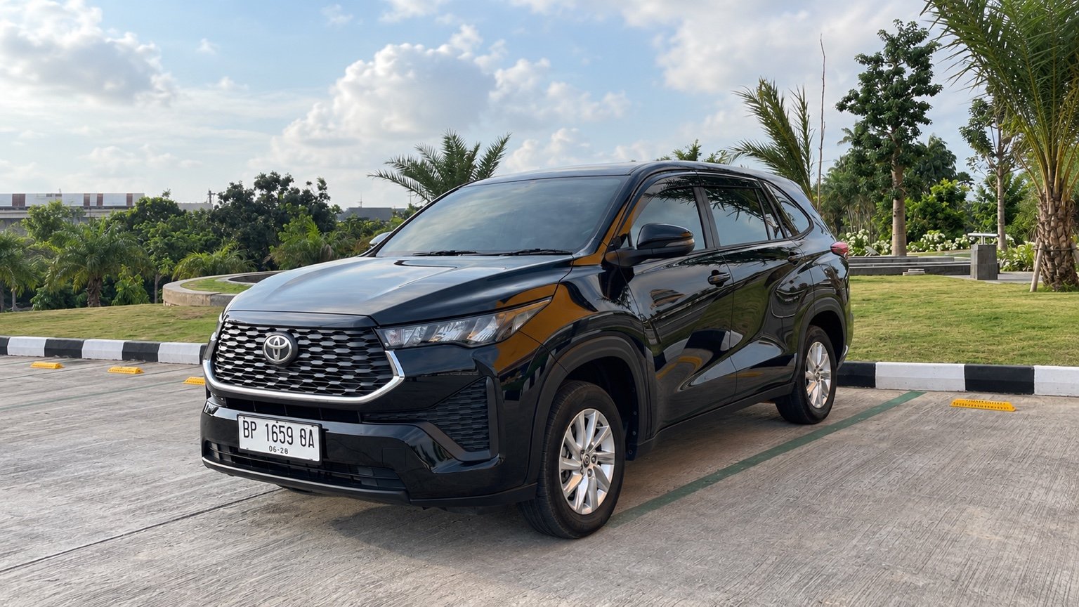 Toyota Innova Zenix hitam, kendaraan utuh dalam foto landscape.