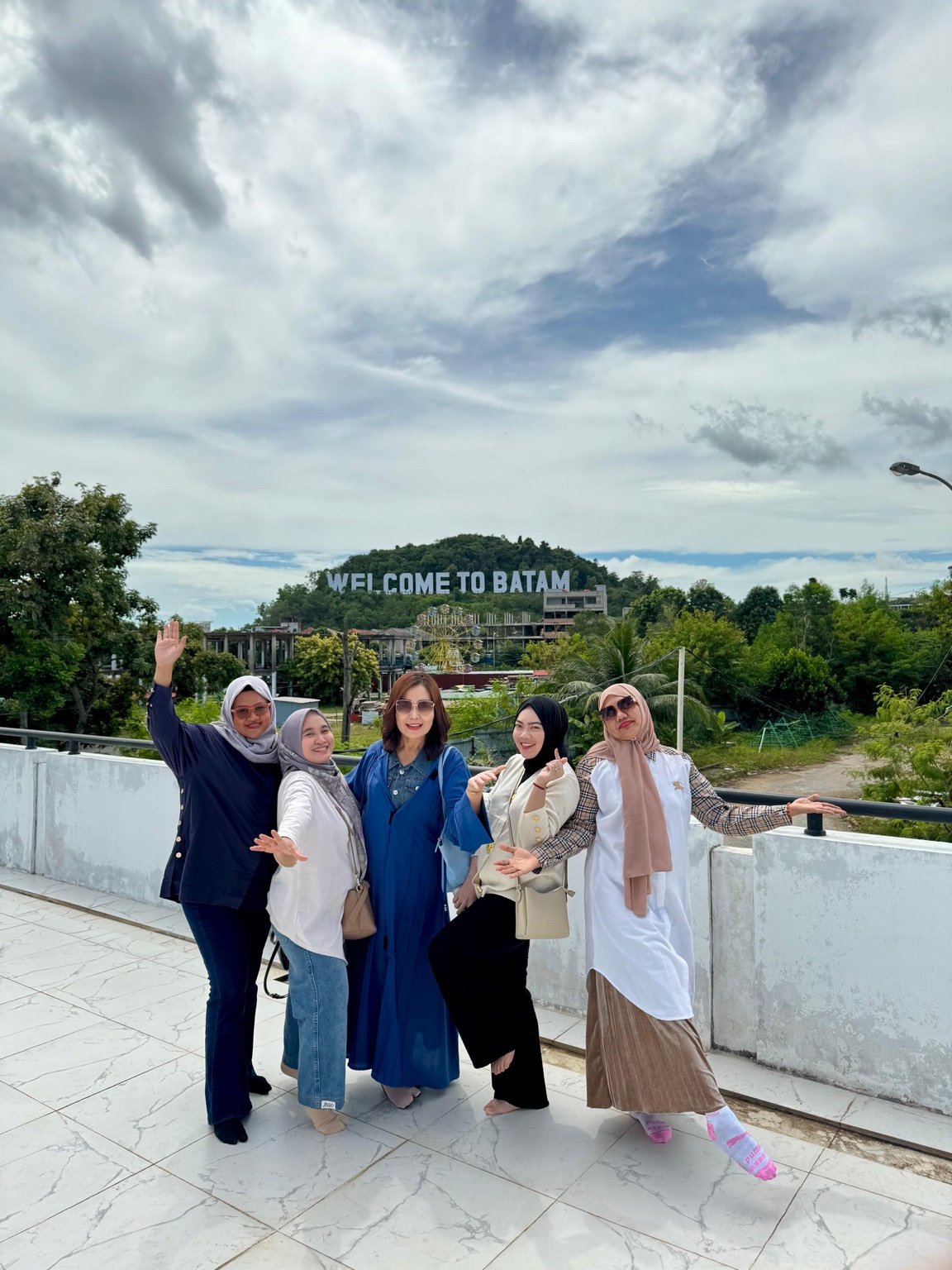 Lima wisatawan dengan tulisan Welcome to Batam di latar belakang