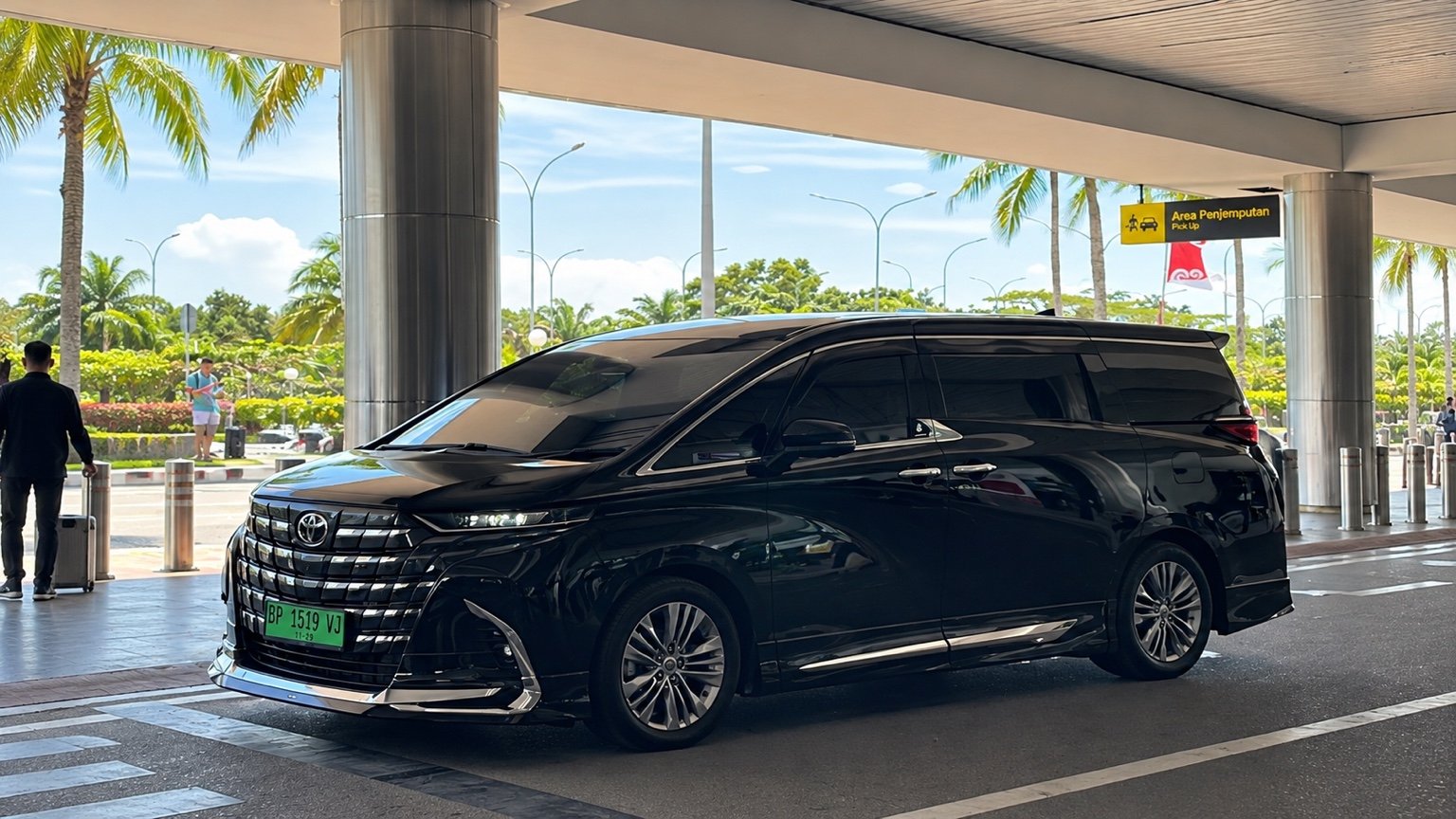 Toyota Alphard hitam di area penjemputan bandara di Batam